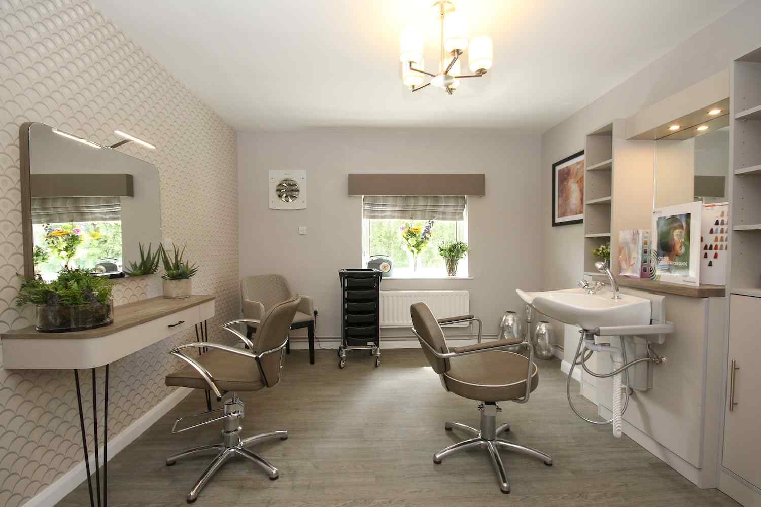 hair salon with 2 chairs, a sink basin and a mirror